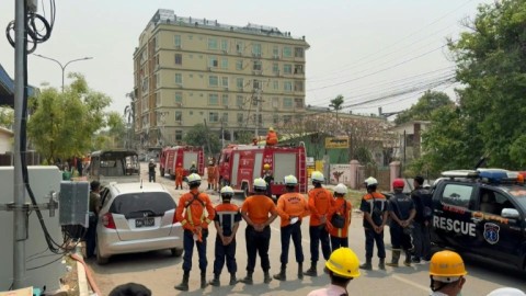 Sirens ring out as an emergency crew near a collapsed apartment building in Myanmar's Mandalay hold a minute of silence in tribute to victims of the earthquake