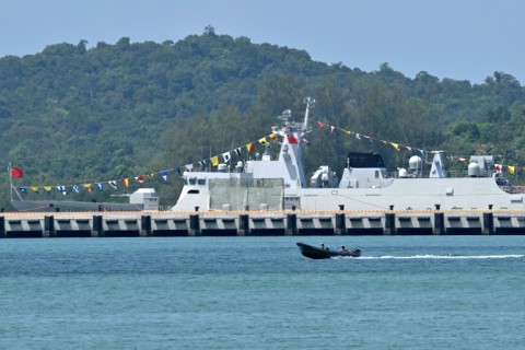 Cambodian soldiers travel on a speedboat near a Chinese warship docked at the Ream Naval Base in Preah Sihanouk province