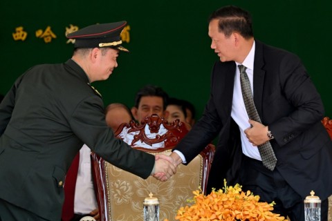 Cambodia's Prime Minister Hun Manet (R) shakes hands with Chinese general Cao Qingfeng (L) during an inauguration ceremony of the renovated Ream Naval Base in Preah Sihanouk province