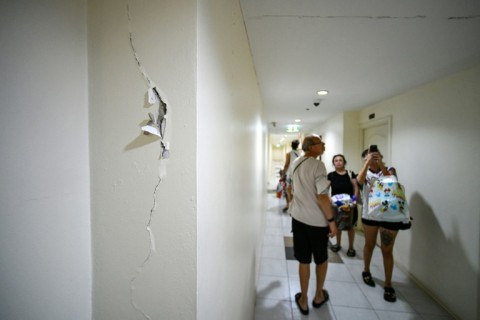 Turkish national Yigit Buyukergun, his wife Lily and her parents walk past cracks along a corridor as they move from a high-rise condo building to a low-rise house due to damage sustained in the March 28 earthquake
