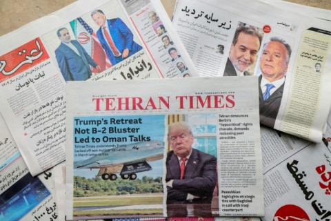 Newspaper front pages featuring the expected Iran-US nuclear talks are displayed at a kiosk in Tehran