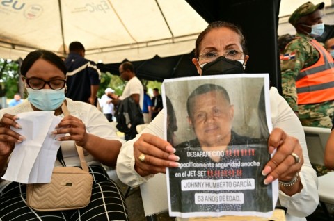 Ayuni Garcia holds a picture of her brother Johnny, who was at the club when its roof collapsed