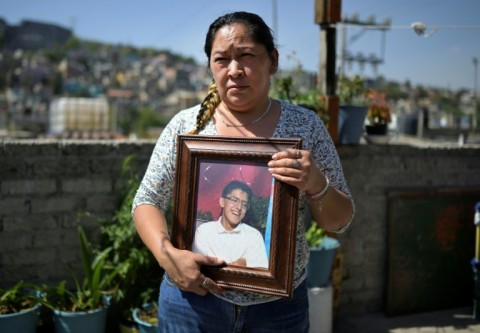 Veronica Cruz holds a portrait of her missing son Robert Reyes