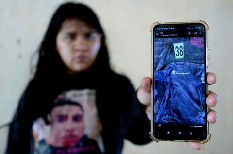 Rubi Cruz shows a photo of a T-shirt she believes belonged to her missing husband that was found at a suspected cartel training camp