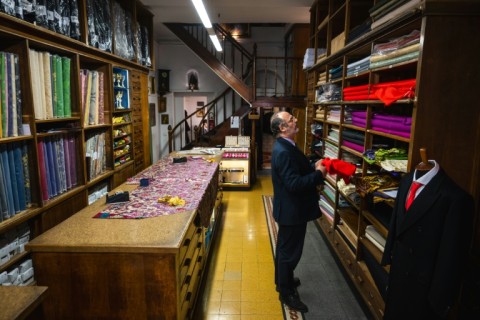 The shop's shelves are heavy with colourful bolts of fabric.