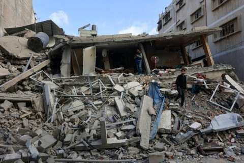 Palestinians inspect the damage after a strike hit a family home in Gaza City