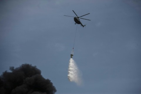 A helicopter helps fight a blaze connected with the blast