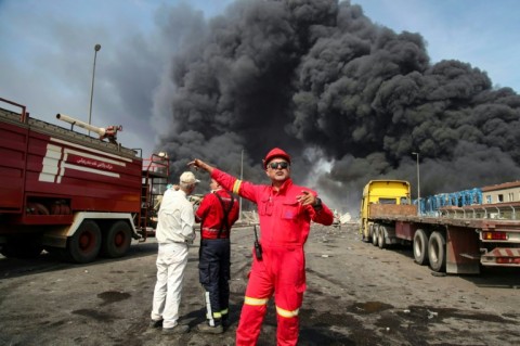Black smoke rises as rescuers arrive near the scene of a deadly explosion at the Shahid Rajaee port in southern Iran