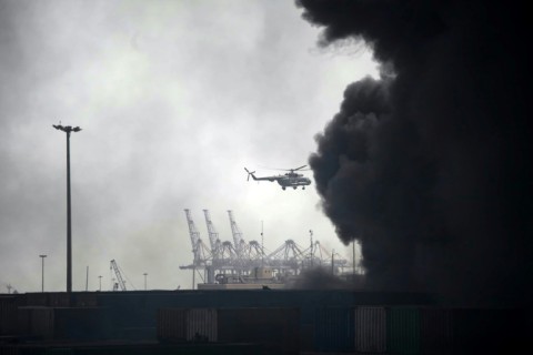 A helicopter flies above Shahid Rajaee port following the huge explosion