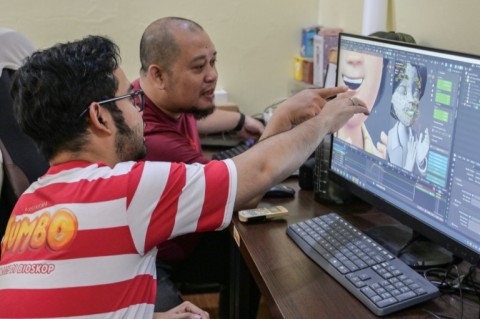 Ryan Adriandhy Halim (L), speaking with a computer illustrator in Jakarta