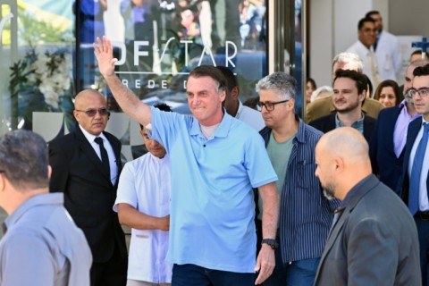 Brazilian former president Jair Bolsonaro waves to supporters as he leaves hospital on May 4, 2025, three weeks after undergoing surgery to treat an intestinal obstruction