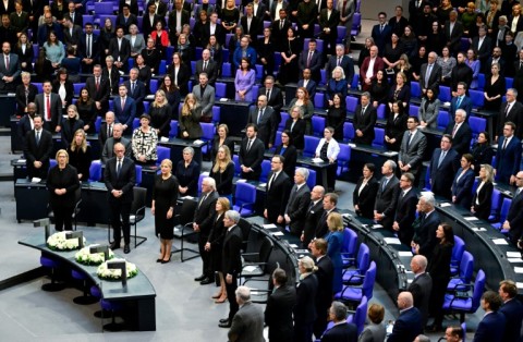 Attendees sing the national anthem at a commemoration ceremony marking 80 years since the defeat of Nazi Germany