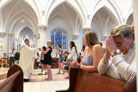 Faithful take communion and pray during a Mass at Saint Thomas of Villanova Church for the new Pope, Leo XIV, an alum of Villanova University in Villanova, Pennsylvania