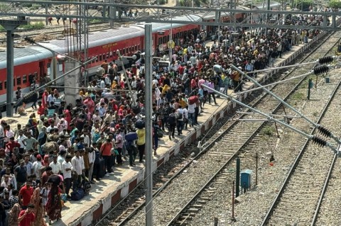 Migrants wait to board a train to leave Jammu in Indian-administered Kashmir