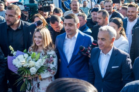 Far-right leader George Simion (C) has the support of former presidential candidate Calin Georgescu (R)