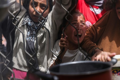 Palestinians wait for food from a charity kitchen in the northern Gaza Strip on Saturday amid an Israeli blockade on aid