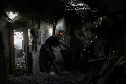 A Palestinian man searches the rubble of a house hit in Israeli strikes on the northern Gaza Strip
