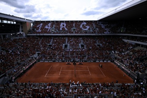 Spectators create the message "14 RG" to honour Rafael Nadal's record amount of French Open titles