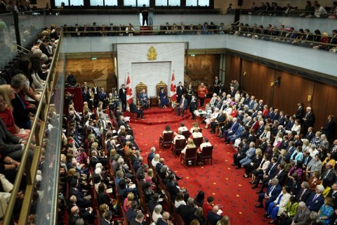 King Charles III (top C) and Queen Camilla open the first session of the 45th Parliament of Canada as Canadian Prime Minister Mark Carney (L) looks on in the Senate