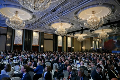 Attendees watch France's President Emmanuel Macron's address at the Shangri-La Dialogue Summit in Singapore