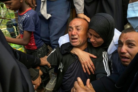 Palestinians mourn relatives killed near a US-backed aid center in the Rafah area, in the southern Gaza Strip