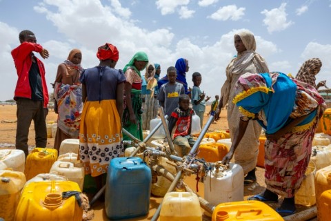 Sudanese refugees fill jerry cans with water at the Touloum refugee camp in Chad