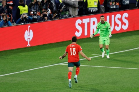 Ruben Neves runs toward Portugal's goalkeeper Diogo Costa after netting the winning penalty