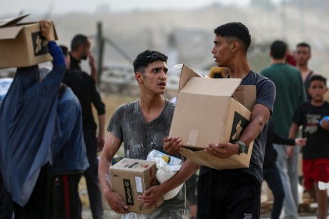 Palestinians carry food aid from the Gaza Humanitarian Foundation