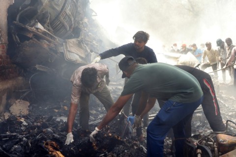Rescue officials work at the site where Air India flight 171 crashed in a residential area near the airport in Ahmedabad