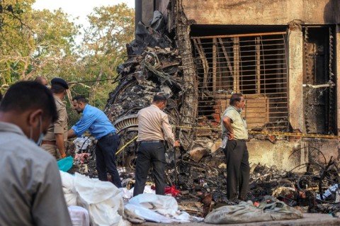 Rescuer workers and investigators comb through the crash site