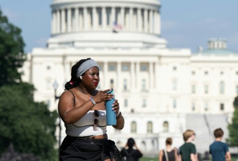 Extreme heat has scorched US cities like the capital Washington, where a woman on the National Mall is seen trying to stay comfortable in the summer weather