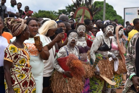 Women adorned in traditional body paint watched the funeral cortege