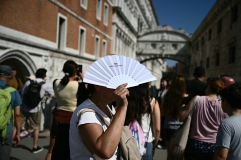 Tourists by the Bridge of Sighs in Venice walking in the heat