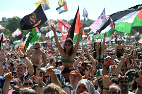 Thousands of festival-goers, many waving Palestinian flags, cheered the band