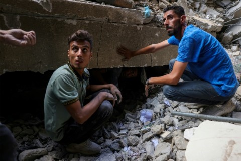 Palestinians look for survivors after an Israeli strike on Gaza City
