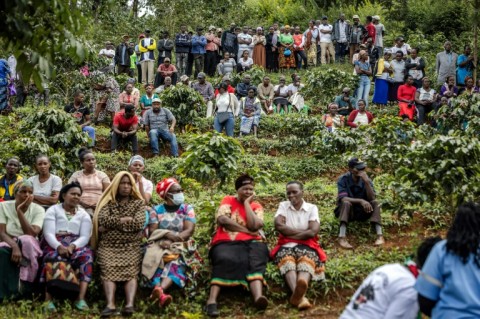 Residents gather on a hill to watch the funeral of 22-year-old mask vendor Boniface Kariuki