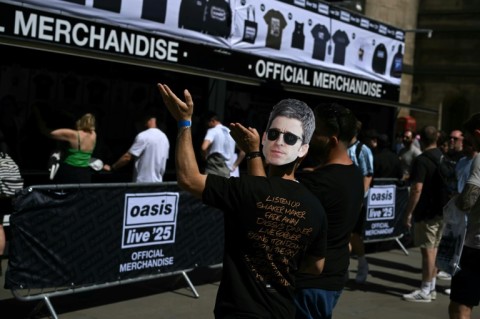 An Oasis fan, wearing a Noel Gallagher mask, queueing to buy official merchandise