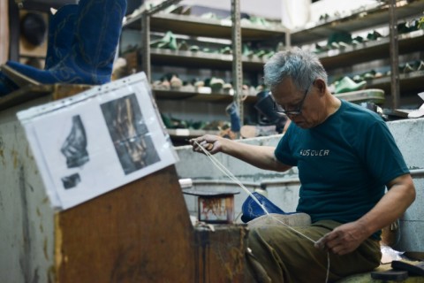 An artisan works on a pair of leather boots for the US market at the workshop of Tegep Boots