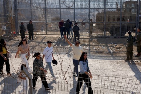 Israeli troops look on as Syrian Druze cross into the Israeli-annexed Golan Heights.