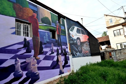 A photo shows old buildings renovated with murals by Bosnian street artist Benjamin Cengic and his creative team who seek to "create bonds" between people