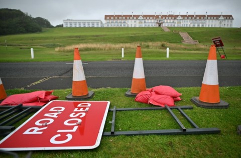 A 'Road Closed' sign is pictured laid on the verge of a road outside the Trump Turnberry hotel