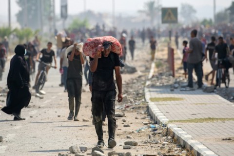 Displaced Palestinians at the Nuseirat refugee camp in Gaza seen hauling hard-to-get food parcels and other items