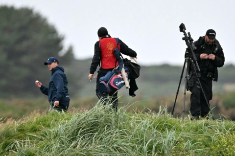 Golfers look for a ball in the rough as snipers and security personnel inspect the area before Trump played another round at his Trump Turnberry Golf Courses, ahead of a key meeting with the EU chief