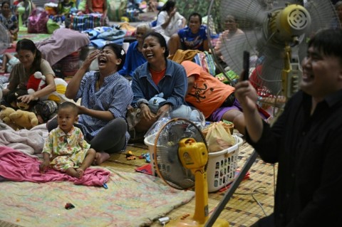 Evacuees laugh at a performance at an shelter in the Thai border province of Surin on July 28 after the ceasefire announcement