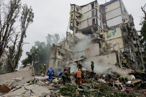 Rescuers clear debris at the site of Sofia and Mykyta's destroyed home