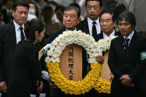 Japan's Prime Minister Shigeru Ishiba (C) prepares to lay a wreath during the annual memorial ceremony
