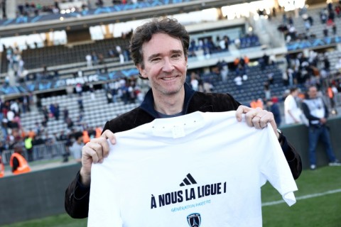 Antoine Arnault, whose family owns Paris FC, holds a t-shirt marking the club's promotion to Ligue 1