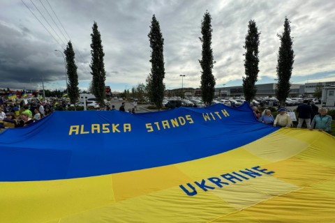 Demonstrators hold a giant Ukrainian flag as they rally in support of Ukraine along Seward Highway in Anchorage, Alaska, on August 14, 2025, on the eve of the scheduled meeting between the US and Russian presidents
