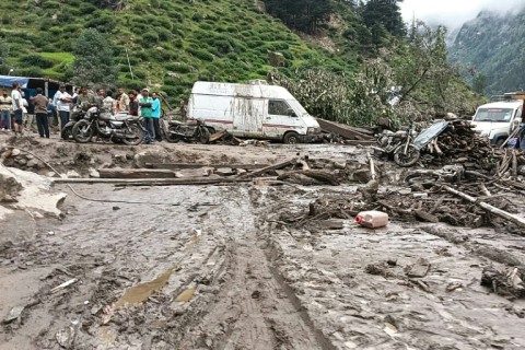 Rescuers inspect the site of a flash flood that has killed at least 60