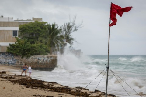 A truck drives through a flooded road as Category 3 Hurricane Erin leaves the region in Naguabo, Puerto Rico